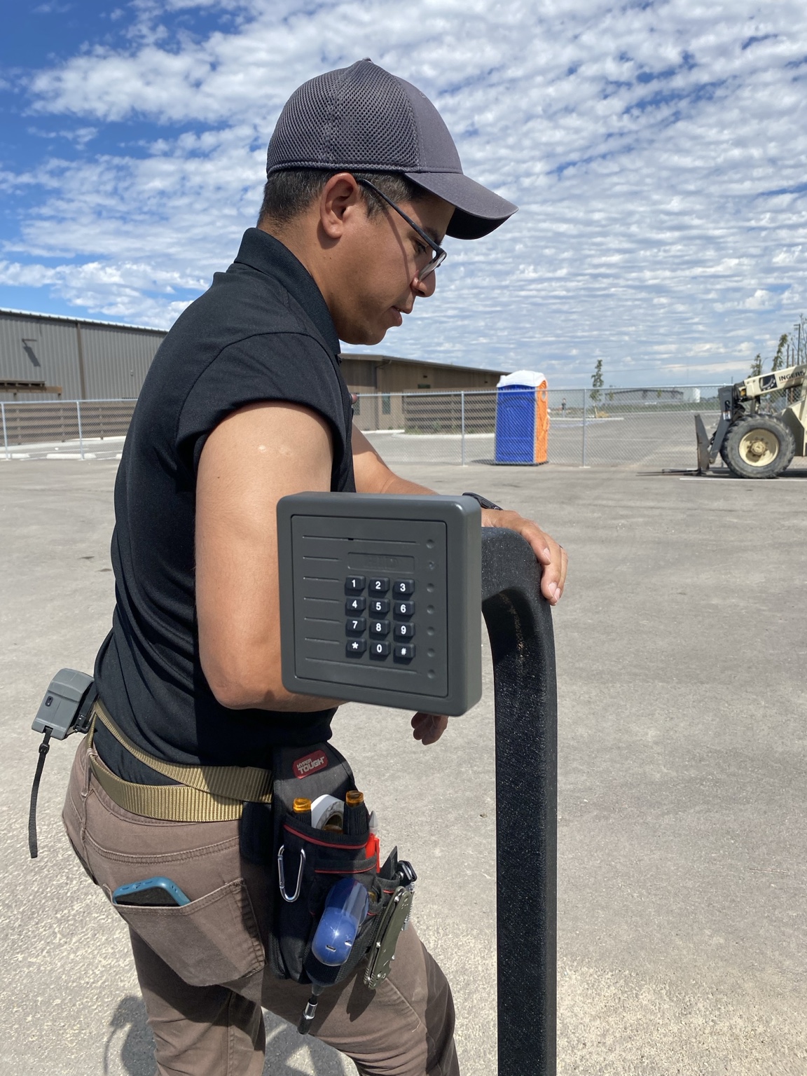 IETEL technician installing an access control keypad at an industrial facility