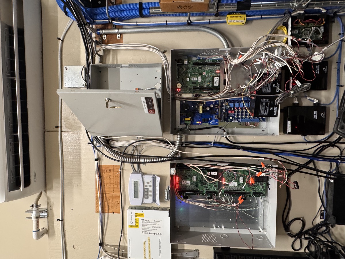 Legacy access control panels with exposed, unorganized wiring before the IETEL deployment.